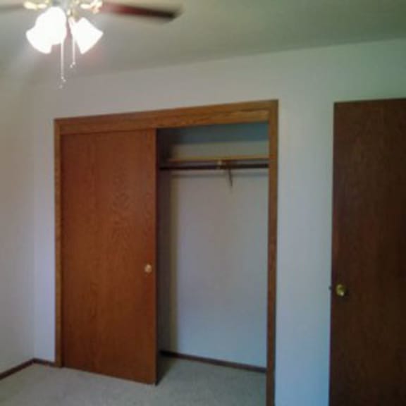 a room with a brown door and a ceiling fan.